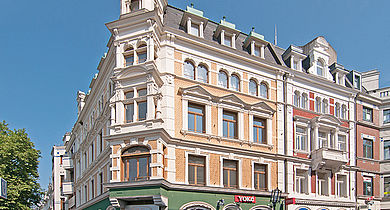 Ein Eckgebäude, Altbau in weiß und gelb/orange
