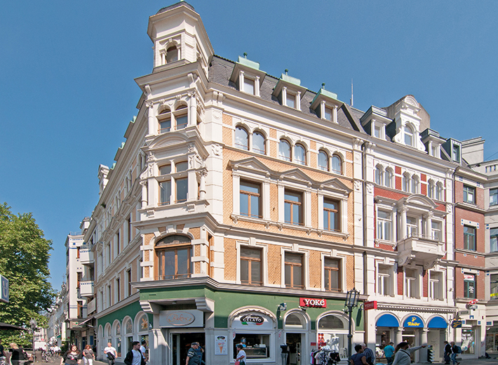 Ein Eckgebäude, Altbau in weiß und gelb/orange